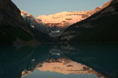 
First Rays Of Sunrise Burn Mount Victoria Yellow Orange Reflected In The Still Waters Of Lake Louise
